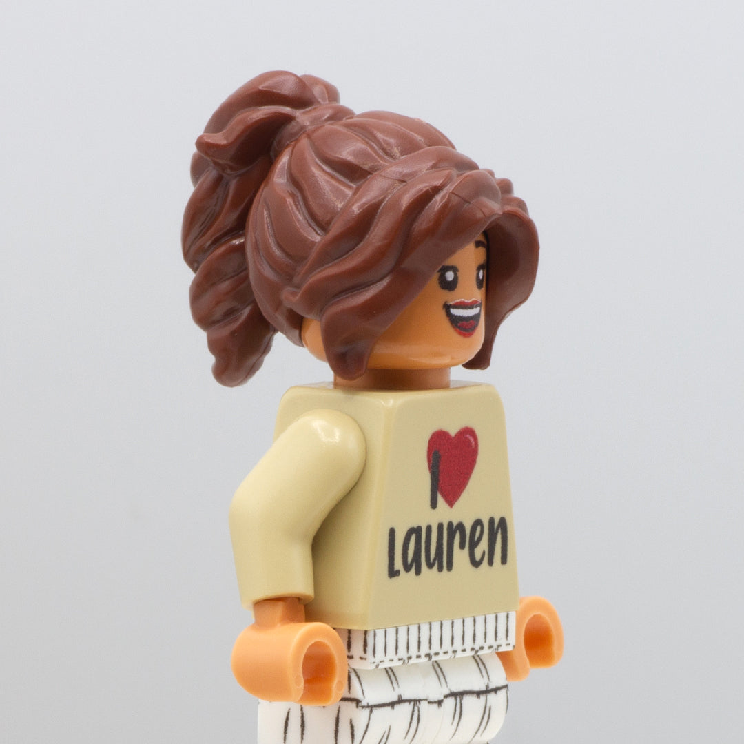 LEGO minifigure wearing brown think and wavy LEGO minifigure hair in a ponytail with parted swept fringe.