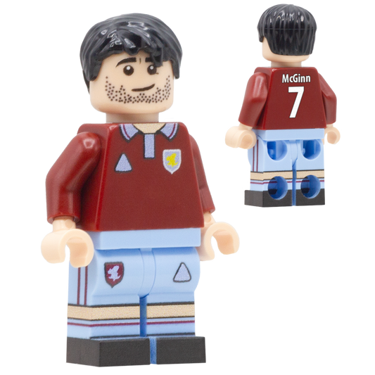 A toy minifigure of Aston Villa FC footballer John McGinn. The figure wears a dark red soccer jersey with a light blue collar, a small yellow star crest, and light blue shorts with dark red stripes.