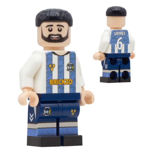 A custom LEGO-style soccer minifigure of Coventry City footballer Matt Grimes. The figure has a black beard and hair, wearing a white and blue striped jersey with 'BRICKZO' on the chest, a blue number 6 on the back, and blue shorts.