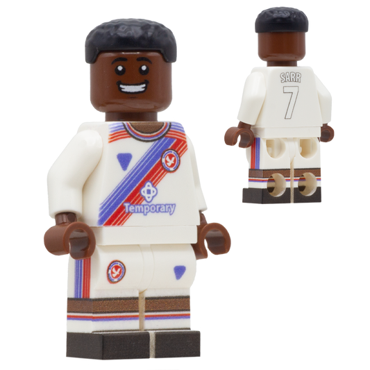 A custom minifigure of a Crystal Palace FC footballer, Ismaila Sarr. The figure has dark brown skin, black hair, and is wearing a white jersey and shorts with red, blue, and brown accents, including the name 'SARR' and number '7' on the back.