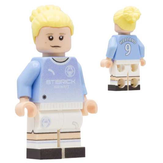 A LEGO minifigure depiciting Erling Haaland with blond hair, a light complexion face; wears a light blue and white Manchester City jersey with the text 'ETBRICK AIRPORT' on the front and 'HARLAND 9' on the back, along with white shorts and black-and-white striped socks.