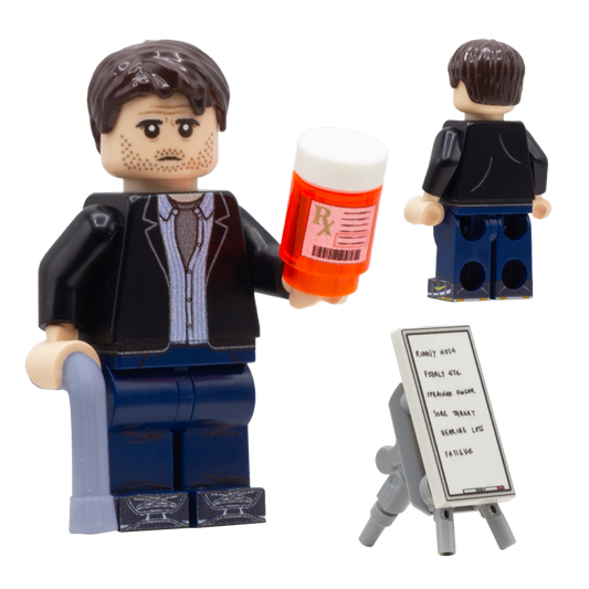 Custom LEGO minifigure inspired by Dr House character from the show, holding a walking stick and a pretend vial of pills.