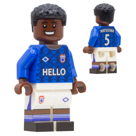 A football toy minifigure of Ipswich Town FC footballer Azor Matusiwa. The figure wears a blue jersey with 'HELLO' across the chest, a crest on the right chest, and 'MATUSIWA 5' on the back, paired with white shorts and brown socks.