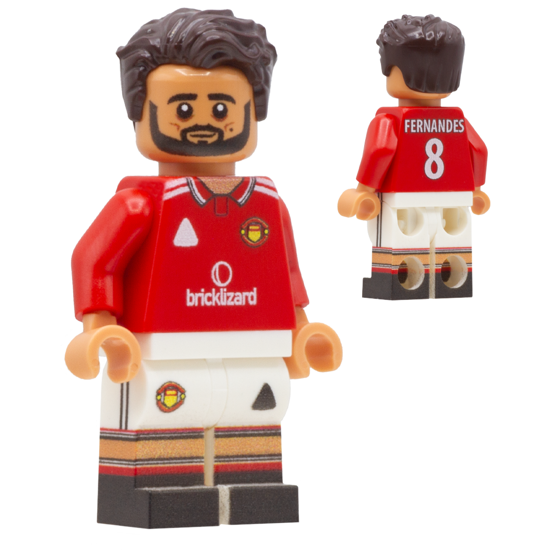 A LEGO-style football minifigure of Manchester United footballer Bruno Fernandes. The figure wears a red jersey with white shorts and striped accents, and the back shows the name FERNANDES and number 8.