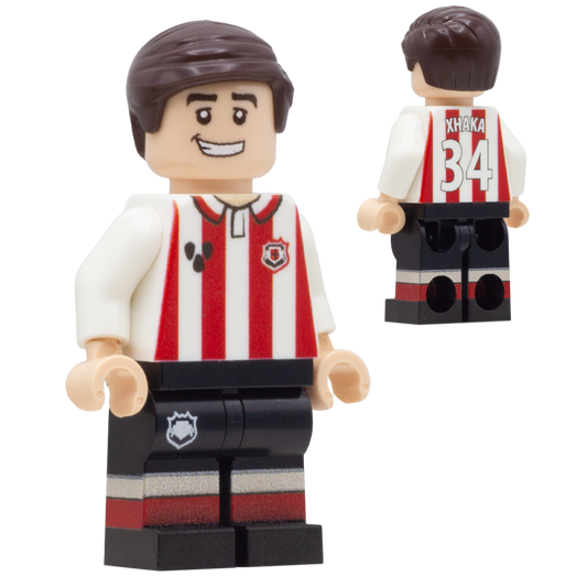 A LEGO-style soccer minifigure of Sunderland FC footballer, Granit Xhaka. The figure wears a red-and-white vertically striped jersey, black shorts with red and white stripes, and brown hair.