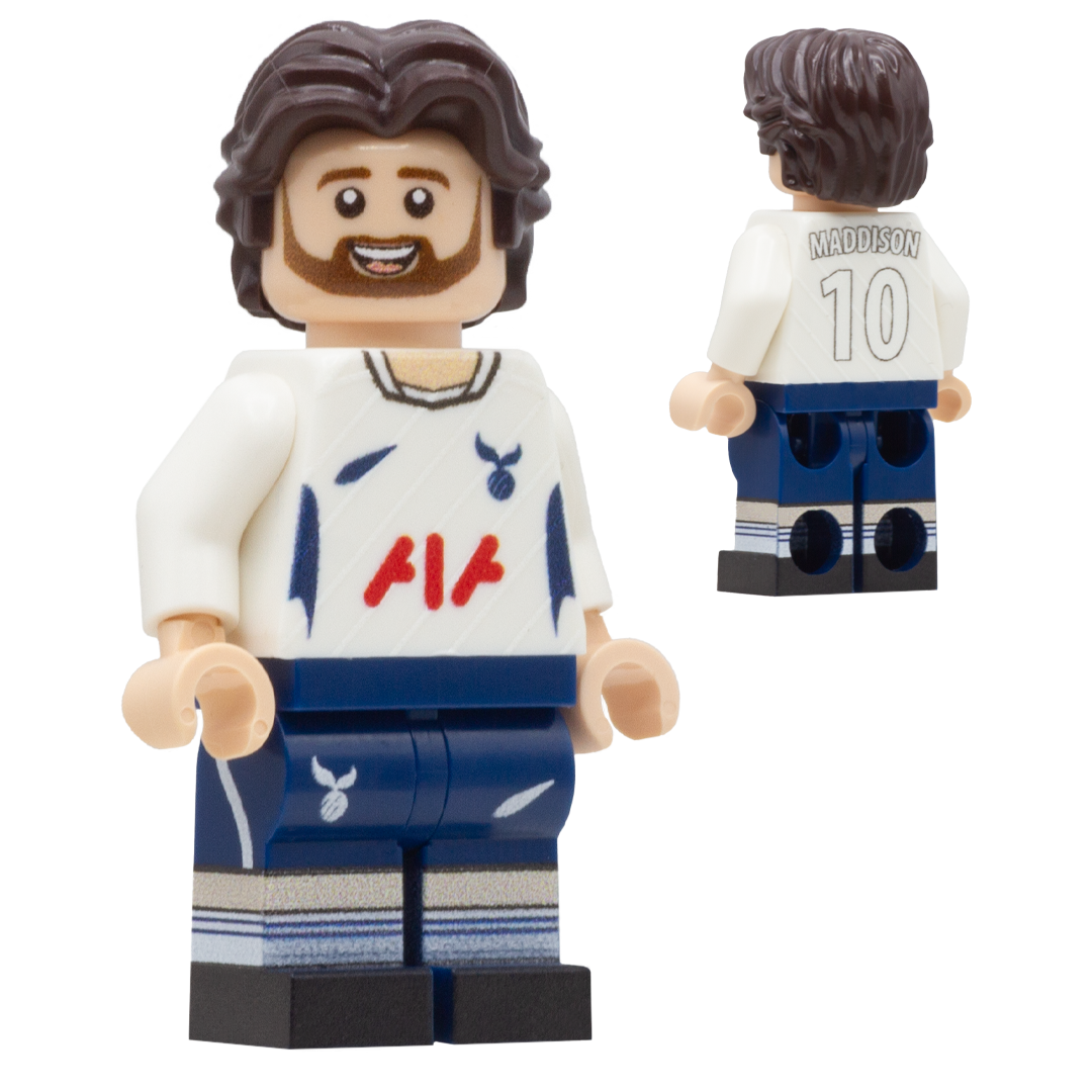 A LEGO-style soccer minifigure of Tottenham Hotspur player, James Maddison. The figure has brown hair and beard, wearing a white jersey with red and blue details and navy shorts.