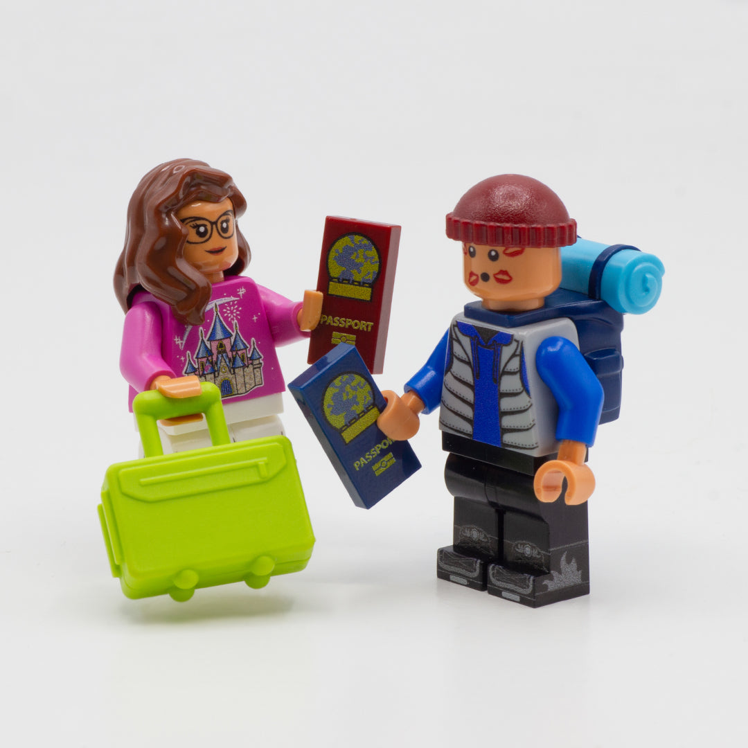 Two LEGO minifigures with some travel accessories, holding passports printed on LEGO tiles.