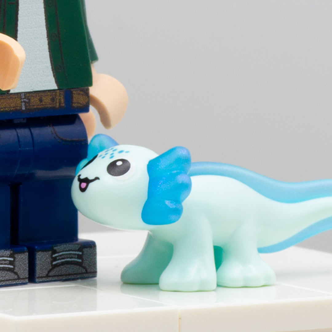 Cute blue LEGO axolotl accessory with big eyes and smile, standing next to LEGO minifigure