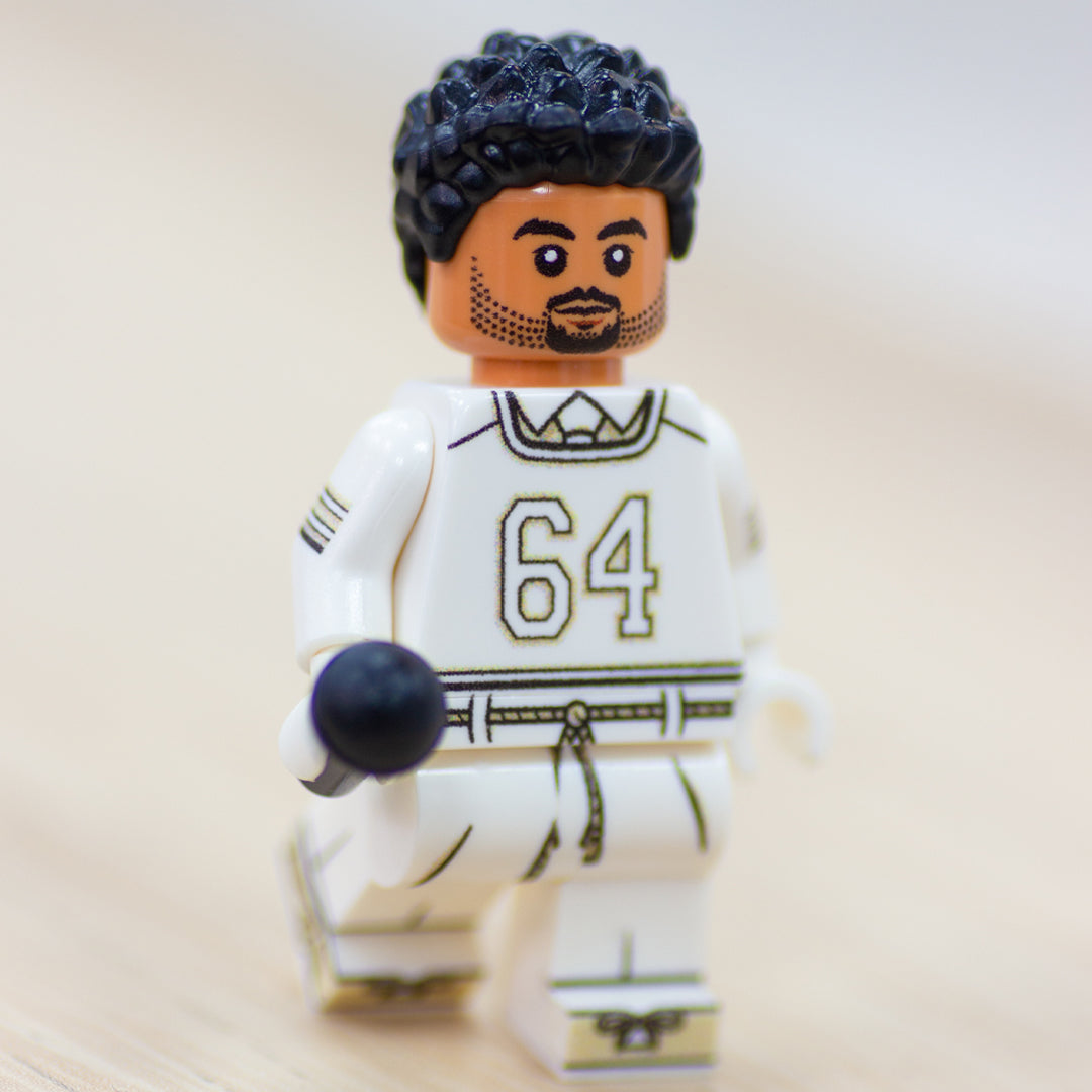 Custom LEGO minifigure inspired by singer, Bad Bunny from his Super Bowl performance, wearing white outfit and holding a microphone. 