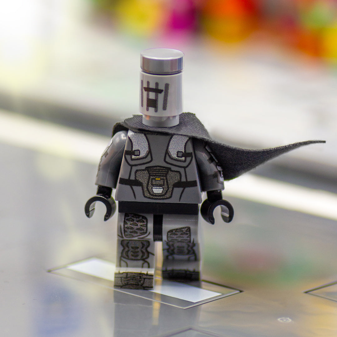 Custom minifigure inspired by Count Binface with printed bin head, printed armour and wearing black cape, walking down the street.