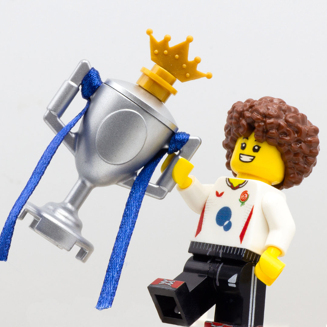 LEGO minifigure cheering and holing a large silver LEGO trophy