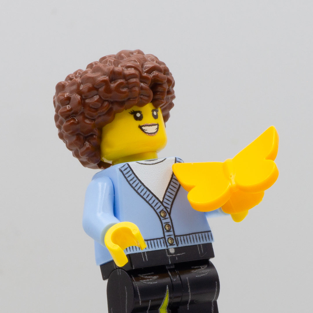 Minifigure holding a yellow LEGO butterfly minifigure accessory.