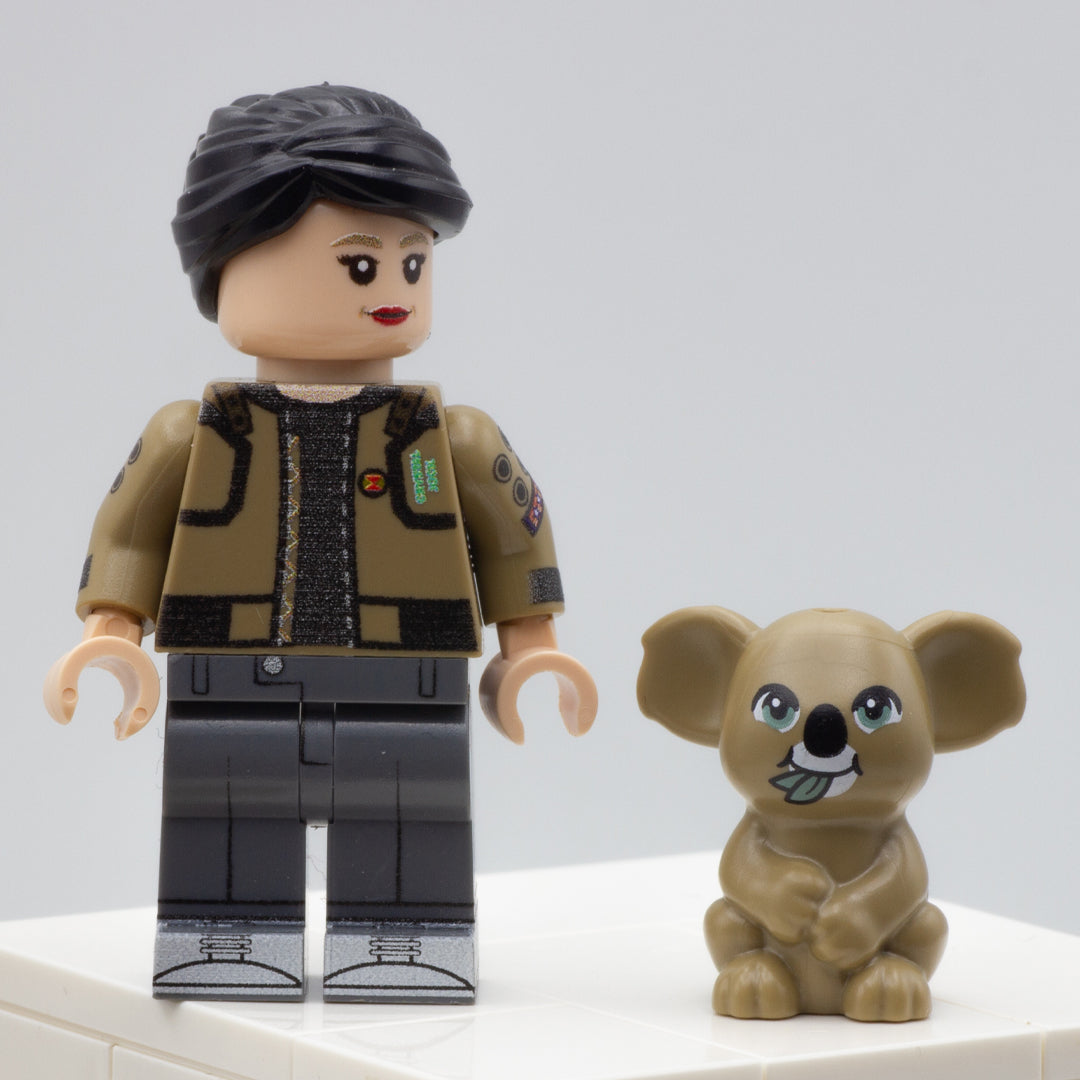 Minifigure standing next to cute dark tan eating LEGO koala with green eyes