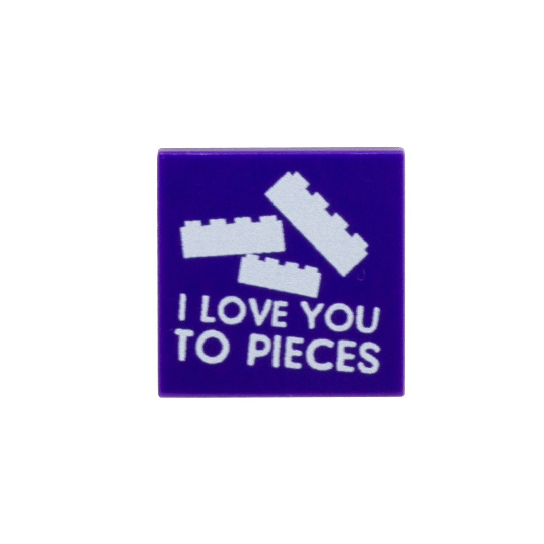 A square purple custom LEGO tile featuring white LEGO-style brick graphics and the text 'I LOVE YOU TO PIECES'.