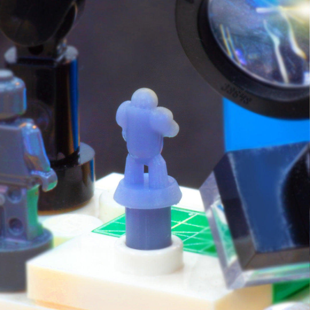 Close-up of a 3-D printed miniature figure standing on a model painting desk.  